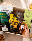Luxury gift hamper for him presented in a magnetic gift box featuring Famous Grouse whisky, Savoursmiths cheddar and shallot crisps, snacking cheese, red onion relish, sea salted caramel biscuits and whisky fudge.