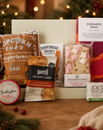 Luxury Christmas letterbox gift hamper featuring gingerbread popcorn, Candy Lane flapjack, buttery shortbread, peppermint tea, cinnamon toast blonde chocolate, artisan sourdough crackers and Christmas chutney presented in a premium Hallby gift box.