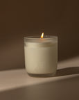 a lit 200g candle featuring a blend of warm amber, refreshing bergamot, tangy orange, sweet vanilla and creamy coconut