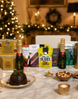 Luxury Christmas champagne gift hamper in a large magnetic gift box featuring two bottles of Moët & Chandon Champagne, Christmas chocolate, grilled olives, snacking cheese, cheddar and shallot crisps, chocolate and orange shortbread, festive nut mix, whisky fudge, mince pie stuffed cookies and Christmas pudding.