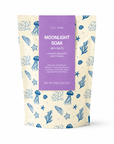 A stand-up pouch of Edit Five Moonlight Soak Bath Salts, featuring a cream-colored background with blue sea-themed illustrations and a central purple label. Edit Five Moonlight Soak relaxing bath salts in sea-themed kraft packaging, designed to soothe tired muscles, soften skin and create a tranquil floral-citrus bathing experience.