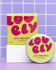 Lovely Juicy Pineapple lip balm with packaging on a purple tiled background