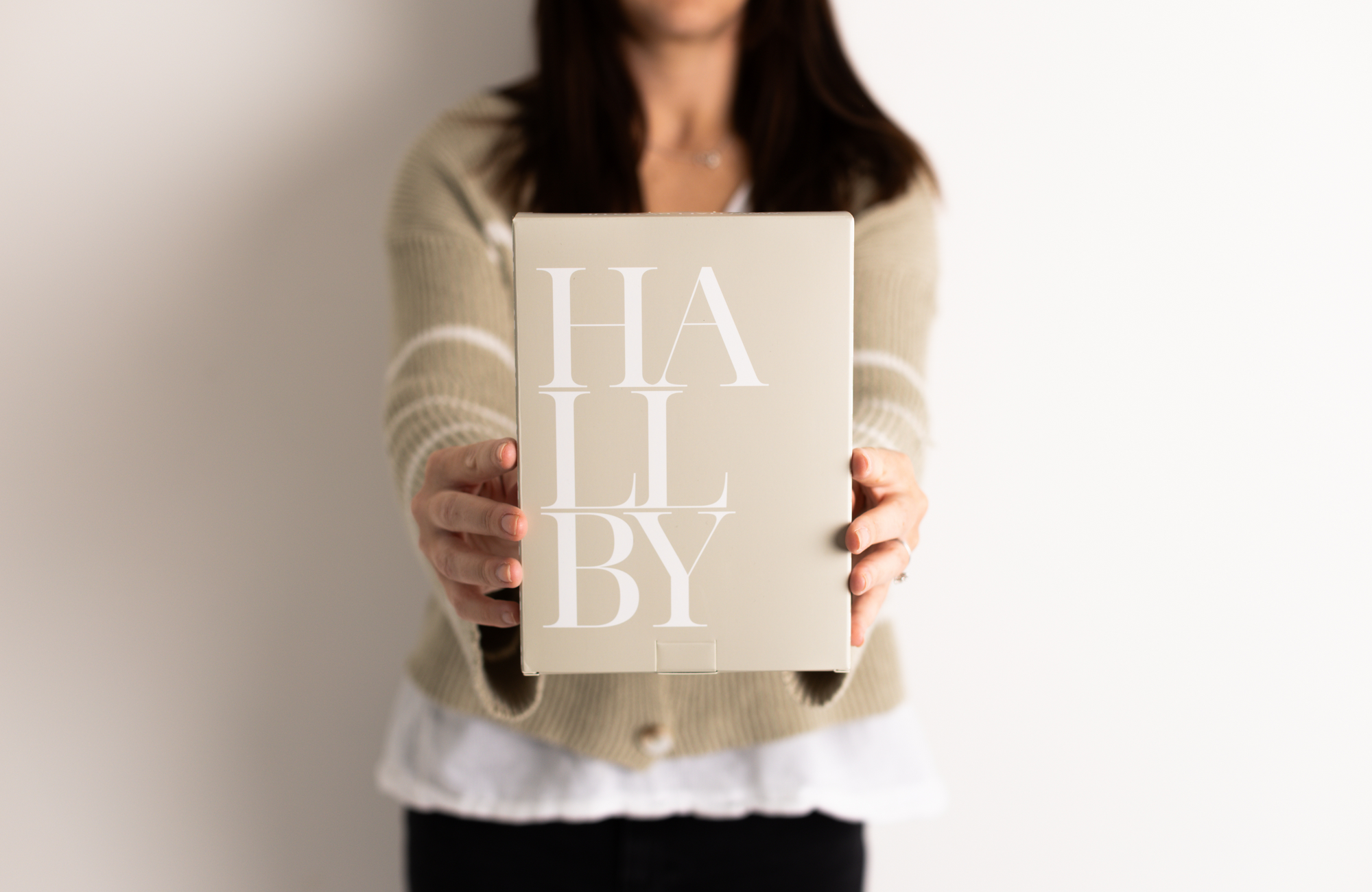 Someone holding Hallby branded gift box.