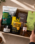 Luxury gift hamper for him presented in a magnetic gift box featuring Famous Grouse whisky, Savoursmiths cheddar and shallot crisps, snacking cheese, red onion relish, sea salted caramel biscuits and whisky fudge.