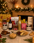 Luxury Christmas food and drink hamper in a large magnetic gift box featuring Bottega Prosecco, red wine, artisan tea, grilled olives, snacking cheese, Wagyu beef and honey mustard crisps, florentines, mince pie stuffed cookies, fruit cake, festive preserves, fudge and seeded flatbreads.
