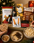 Luxury Christmas letterbox gift hamper featuring Baileys Irish Cream, English Breakfast tea, cinnamon roll popcorn, salted caramel chocolate, zesty lime and chilli peanut and cashew mix, and all-butter shortbread presented in a premium Hallby gift box.