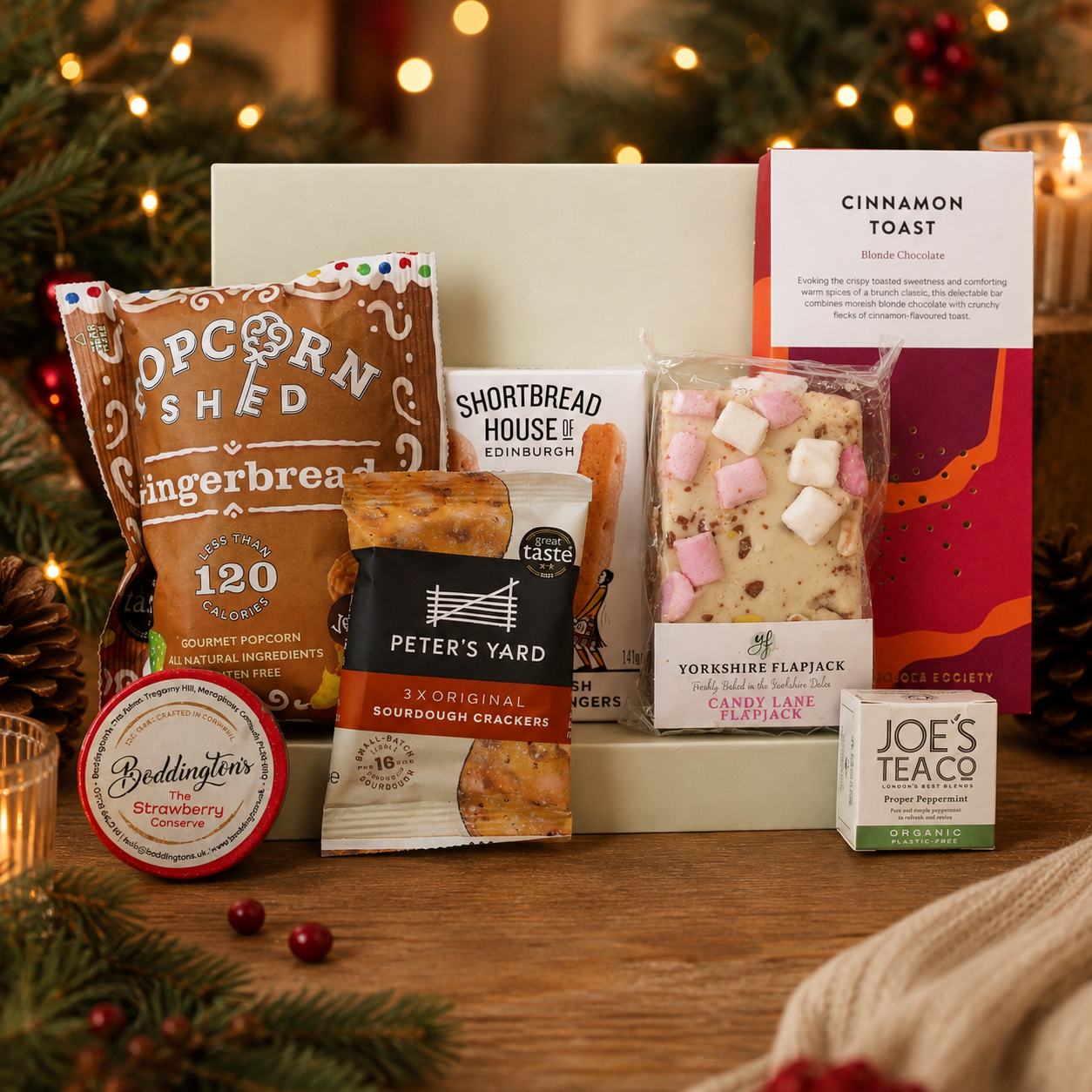 Luxury Christmas letterbox gift hamper featuring gingerbread popcorn, Candy Lane flapjack, buttery shortbread, peppermint tea, cinnamon toast blonde chocolate, artisan sourdough crackers and Christmas chutney presented in a premium Hallby gift box.