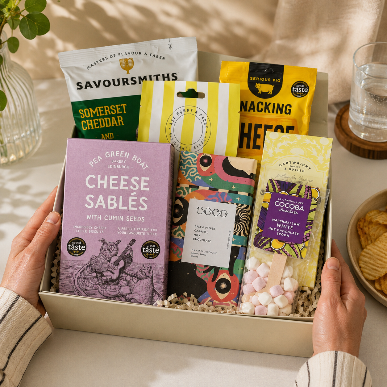 Luxury gourmet gift hamper in a premium magnetic gift box featuring lemon shortbread, cookies and cream popcorn, snacking cheese, limoncello gummies, salted caramel chocolate, red onion relish, cheese sablés and a marshmallow white hot chocolate spoon.