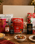 Luxury Christmas gift hamper in a premium magnetic gift box featuring Christmas pudding popcorn, festive munch mix, Wagyu beef and honey mustard crisps, artisan dark chocolate, Candy Lane flapjack, The Famous Grouse whisky and Jack Daniel's whiskey.
