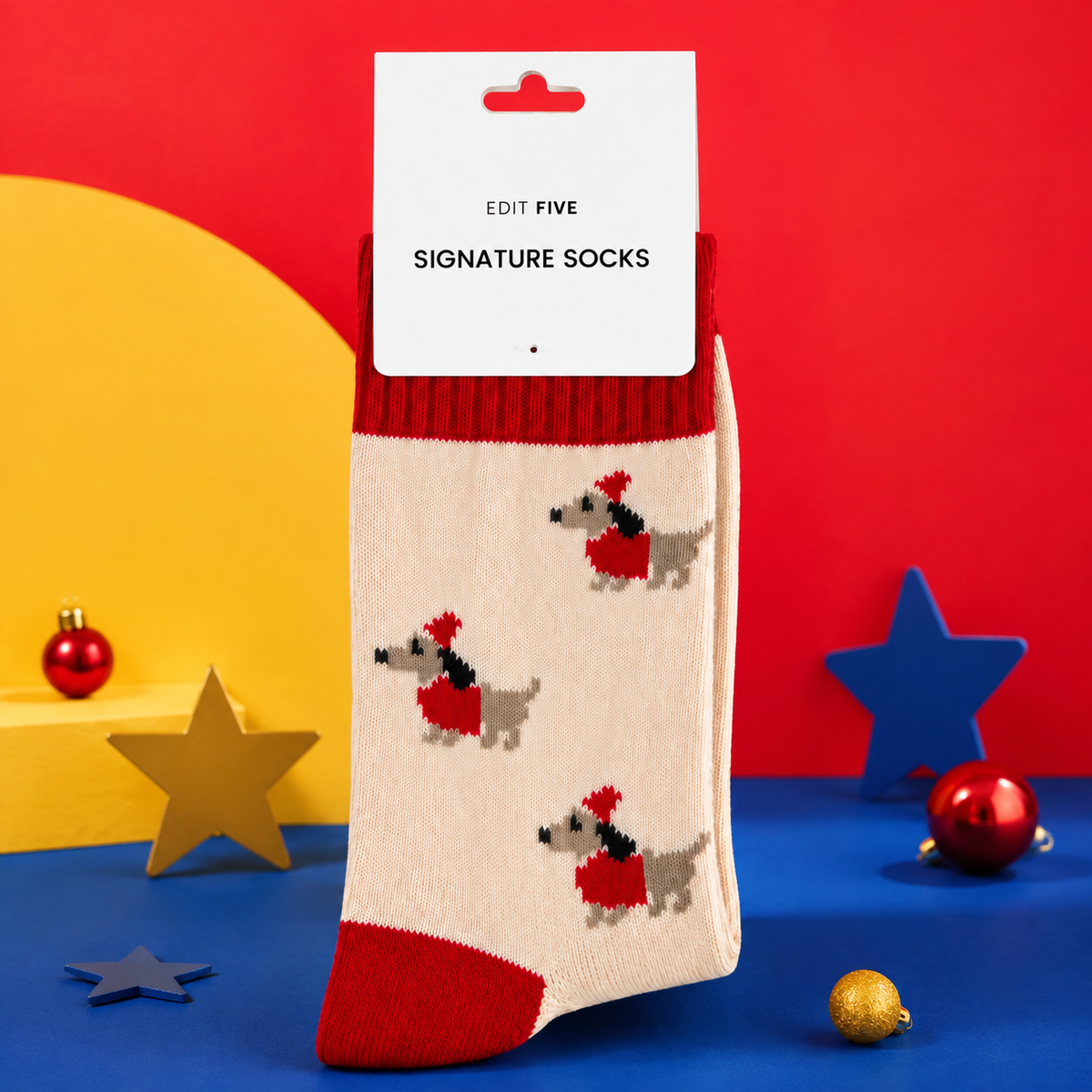 Cream festive dachshund socks featuring sausage dogs in Santa hats and red jumpers, with contrasting red cuffs, heels and toes. dachshund socks, Soft, cosy Christmas socks in UK sizes 4–8.
