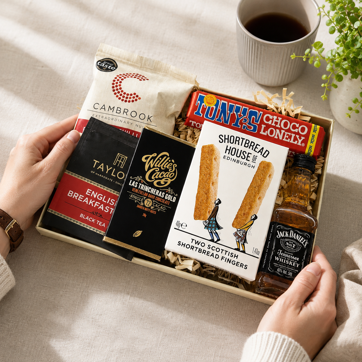 Luxury letterbox gift hamper for him featuring Jack Daniel's whiskey, artisan chocolate, English breakfast tea, sweet chilli peanuts and shortbread presented in a premium Hallby gift box.