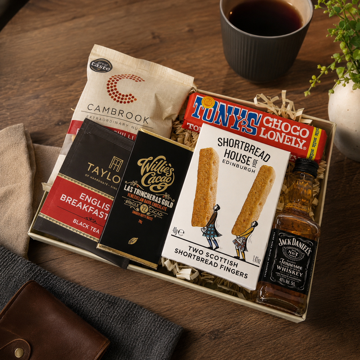 Luxury letterbox gift hamper for him featuring Jack Daniel's whiskey, artisan chocolate, English breakfast tea, sweet chilli peanuts and shortbread presented in a premium Hallby gift box.
