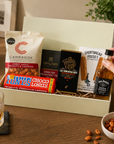Luxury letterbox gift hamper for him featuring Jack Daniel's whiskey, artisan chocolate, English breakfast tea, sweet chilli peanuts and shortbread presented in a premium Hallby gift box.