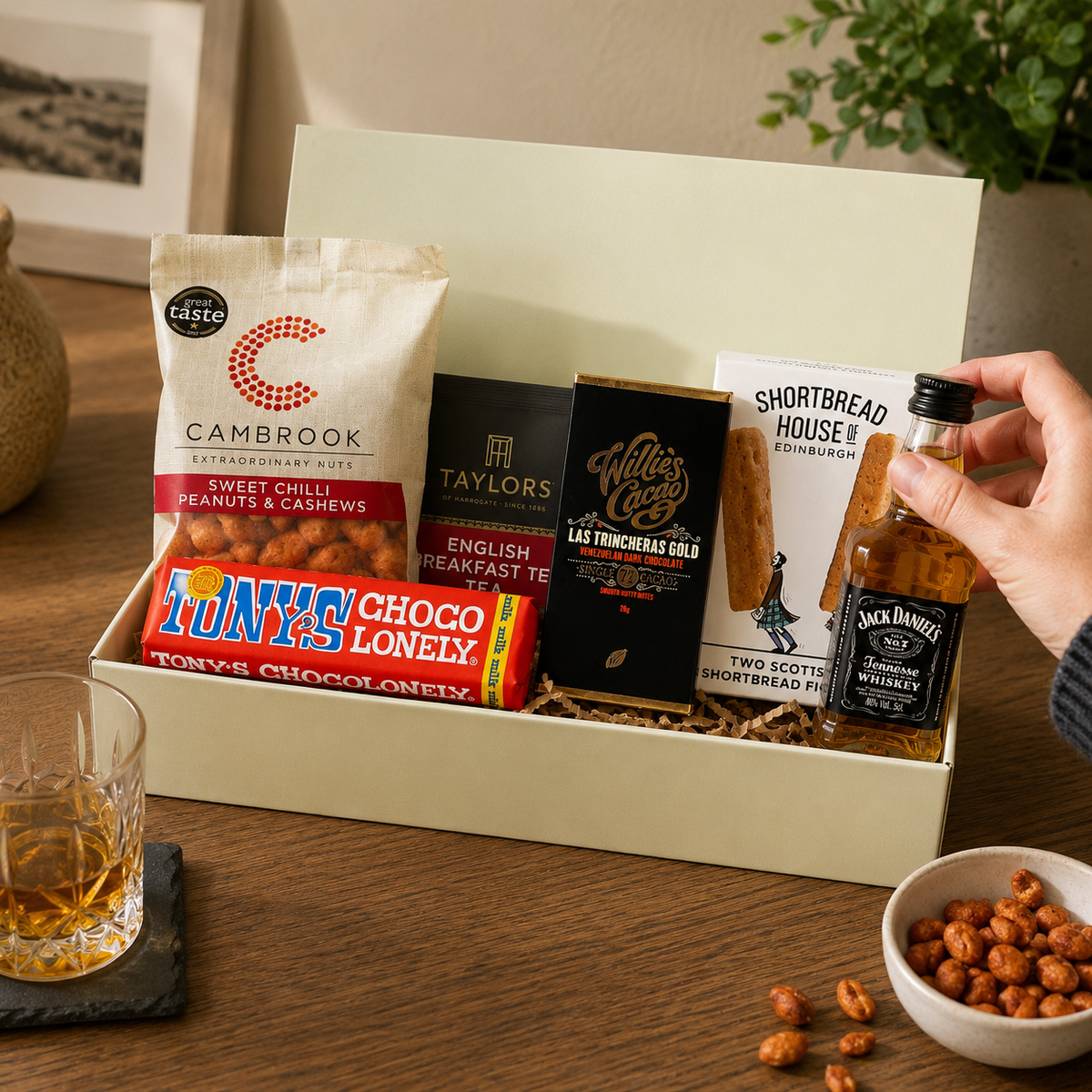 Luxury letterbox gift hamper for him featuring Jack Daniel's whiskey, artisan chocolate, English breakfast tea, sweet chilli peanuts and shortbread presented in a premium Hallby gift box.