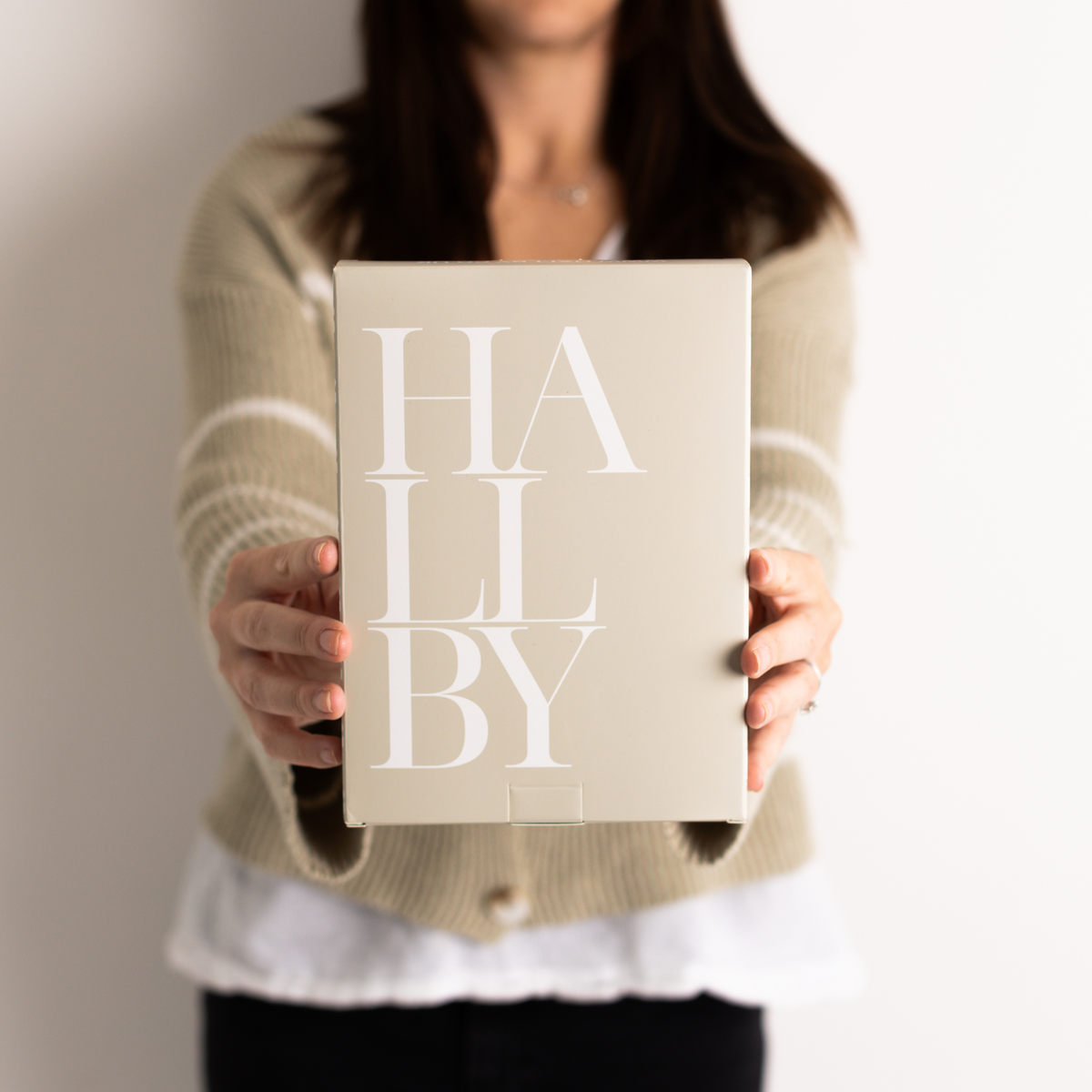 Someone holding one of the Hallby branded gift boxes.