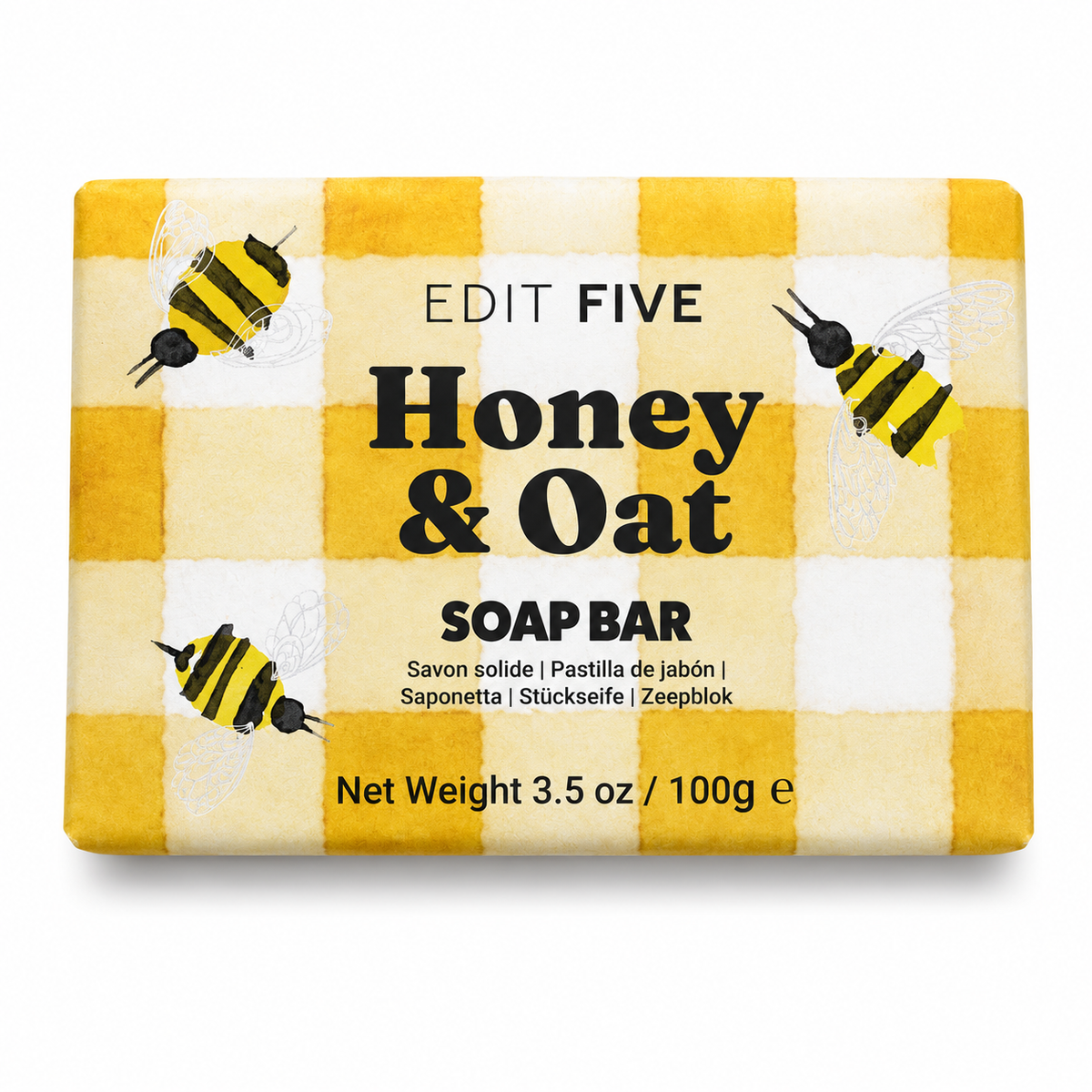 A rectangular bar of soap wrapped in a yellow and white gingham patterned paper sleeve decorated with illustrations of honey bees. The text on the wrapper reads 'EDIT FIVE Honey &amp; Oat SOAP BAR' - Traditional honey and oat soap handmade in England—a mild artisan cleansing bar for everyday skincare, relaxing showers, bath-time rituals and thoughtful wellbeing gifts.