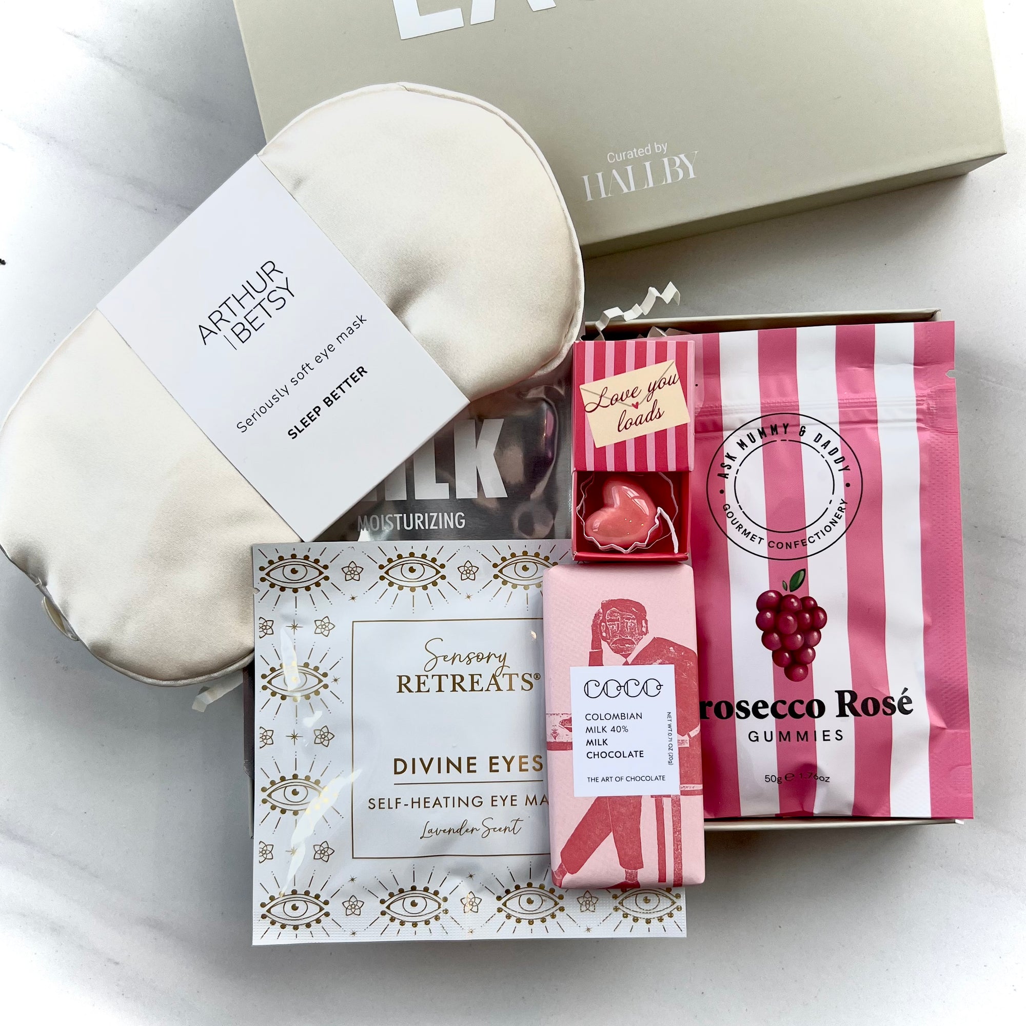 Collection of self-care products including eye masks and gummies on a white surface.