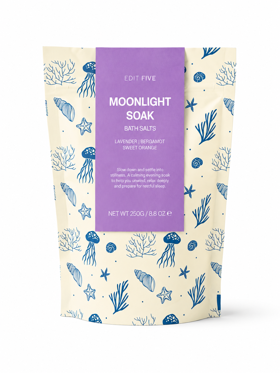 A stand-up pouch of Edit Five Moonlight Soak Bath Salts, featuring a cream-colored background with blue sea-themed illustrations and a central purple label. Edit Five Moonlight Soak relaxing bath salts in sea-themed kraft packaging, designed to soothe tired muscles, soften skin and create a tranquil floral-citrus bathing experience.