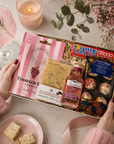 Luxury pink letterbox gift hamper featuring Gordon's Pink Gin, Prosecco Rosé gummies, Tony's Chocolonely milk chocolate, chocolate chunk shortbread slice and raspberry Marc de Champagne truffles presented in a premium Hallby gift box.