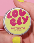Lip balm container with 'lovely' branding held by a hand