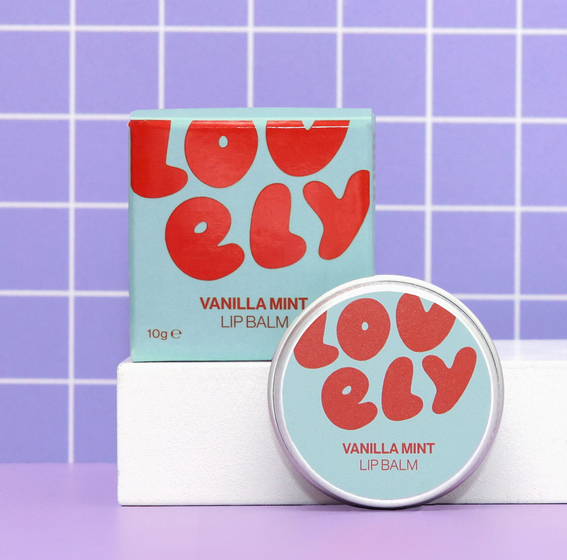 Lovely Vanilla Mint lip balm with packaging on a purple grid background