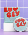 Lovely Vanilla Mint lip balm with packaging on a purple grid background