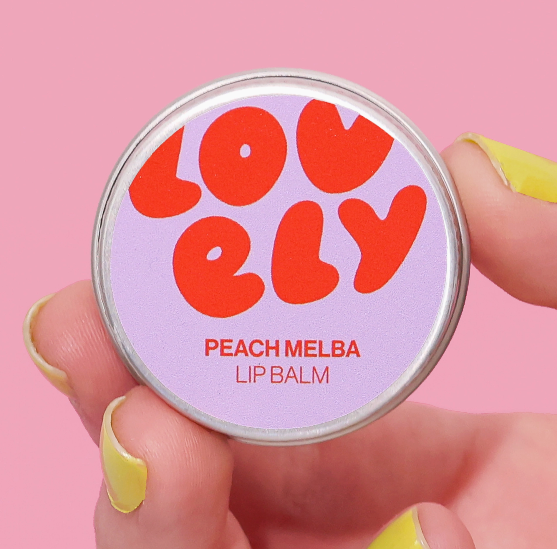 Lip balm container with 'LOVELY' branding on a pink background