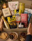 Luxury gourmet gift hamper in a large magnetic gift box featuring Bottega Prosecco, lemon shortbread tin, whisky fudge, grilled olives, pistachios, artisan cheese sablés, snacking cheese, salt and vinegar crisps, red onion relish, seeded flatbreads and fizzy mix sweets.