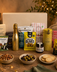 Luxury gourmet gift hamper in a large magnetic gift box featuring Bottega Prosecco, lemon shortbread tin, whisky fudge, grilled olives, pistachios, artisan cheese sablés, snacking cheese, salt and vinegar crisps, red onion relish, seeded flatbreads and fizzy mix sweets.