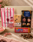 Luxury pink letterbox gift hamper featuring Gordon's Pink Gin, Prosecco Rosé gummies, Tony's Chocolonely milk chocolate, chocolate chunk shortbread slice and raspberry Marc de Champagne truffles presented in a premium Hallby gift box.