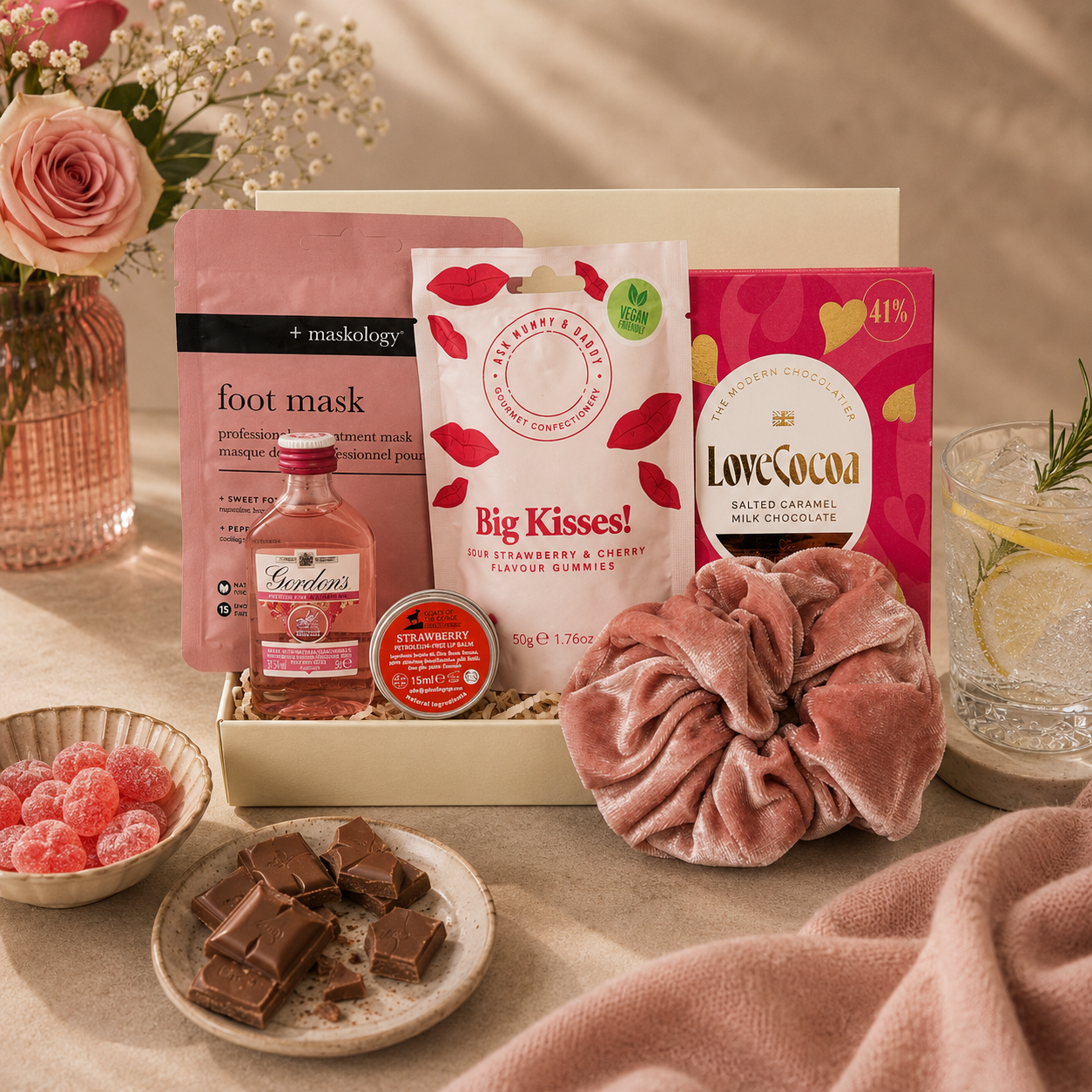 Luxury pink letterbox gift hamper featuring Gordon's Pink Gin, strawberry lip balm, pink velvet scrunchie, hydrating foot mask, salted caramel milk chocolate and an 'Ask Mummy and Daddy – Big Kisses' keepsake in a premium Hallby gift box.