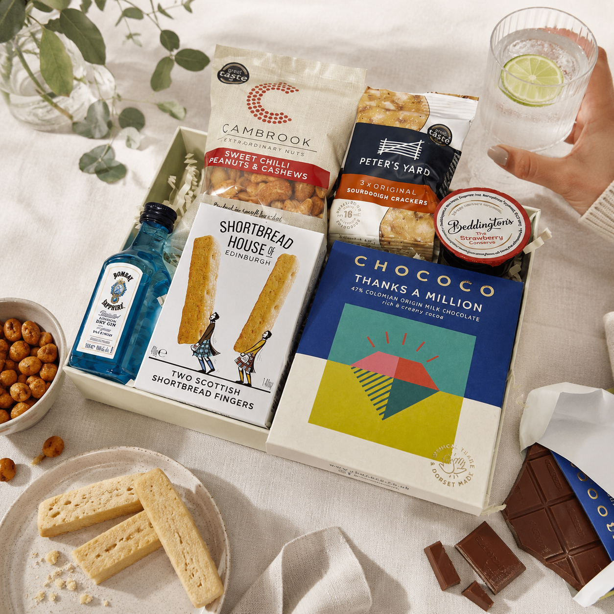 Luxury thank you letterbox gift hamper with Thanks a Million chocolate bar, Bombay Sapphire gin, sweet chilli peanuts and cashews, artisan shortbread, sourdough crackers and strawberry conserve in a premium Hallby gift box.